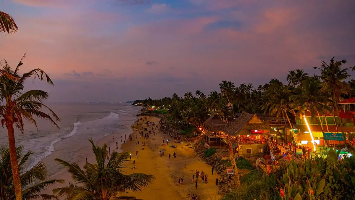 Varkala beach at dusk, the clifftop cafés lit up above the sand and the surf